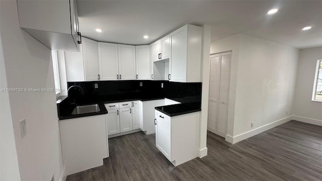 kitchen featuring backsplash, white cabinetry, sink, and dark hardwood / wood-style flooring