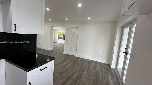 kitchen featuring dark stone countertops, white cabinetry, and dark hardwood / wood-style flooring