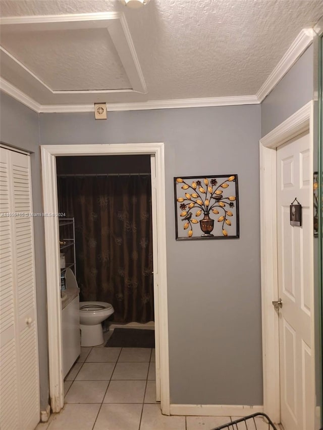 bathroom featuring crown molding, toilet, tile patterned flooring, and a textured ceiling