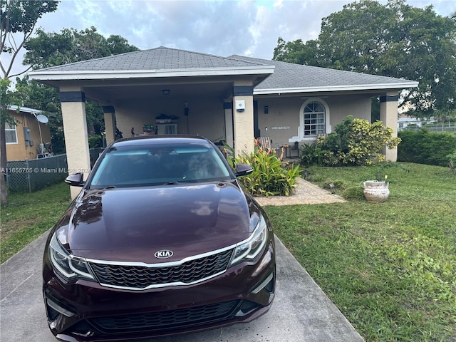 2239 Atlanta St, Hollywood, FL 33020 - view of front facade featuring fence, stucco siding, a shingled roof, an attached carport, and a front lawn