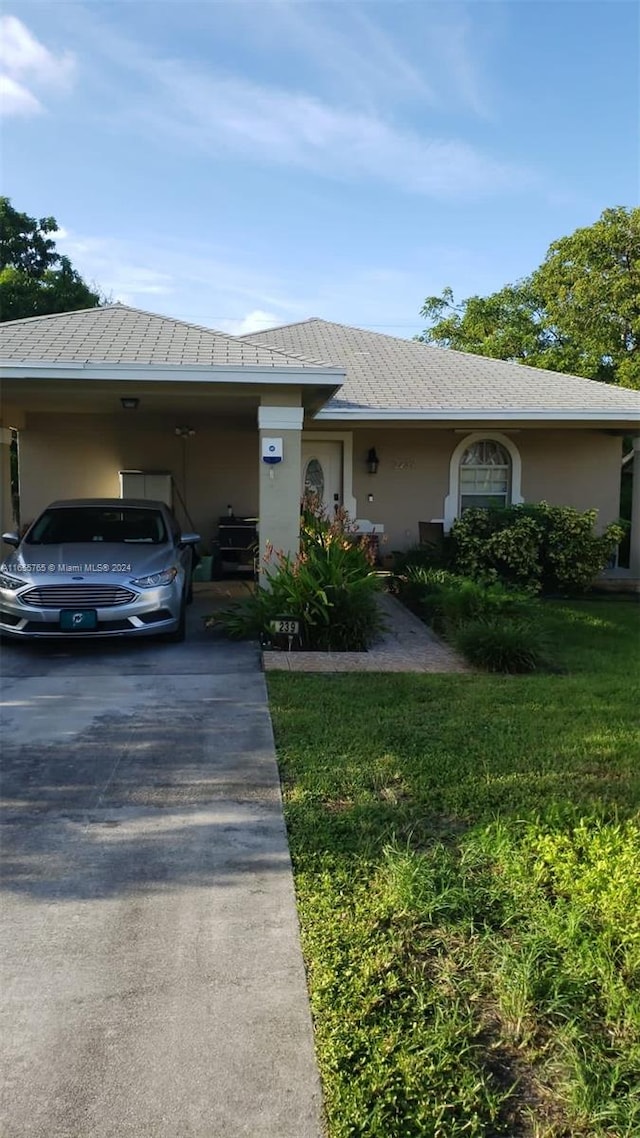 ranch-style home with a front yard and a carport