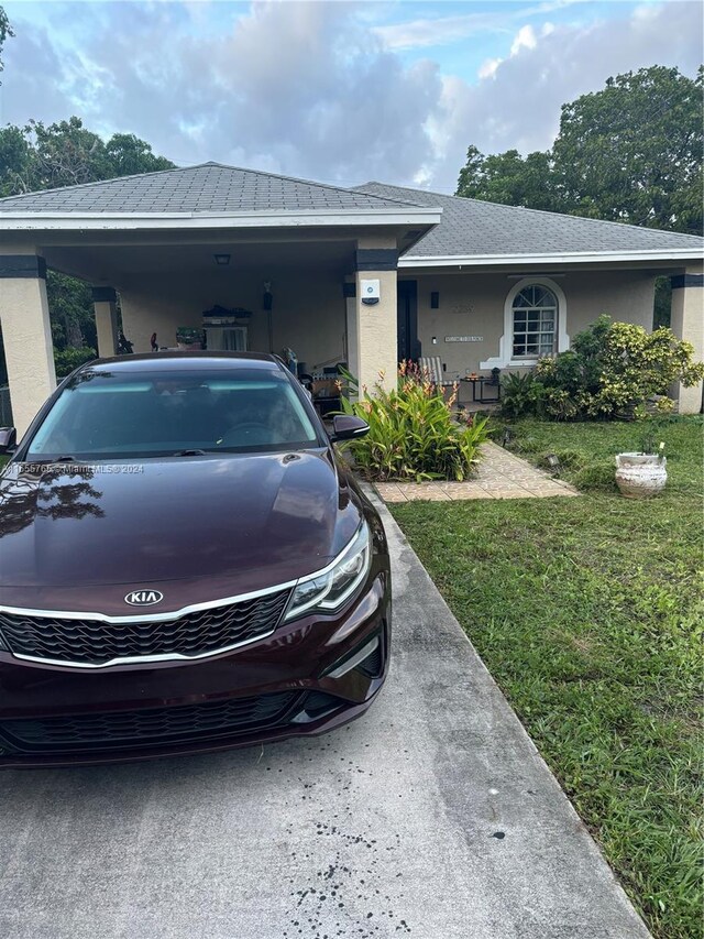 2239 Atlanta St, Hollywood, FL 33020 - ranch-style house featuring a front lawn, stucco siding, and a carport