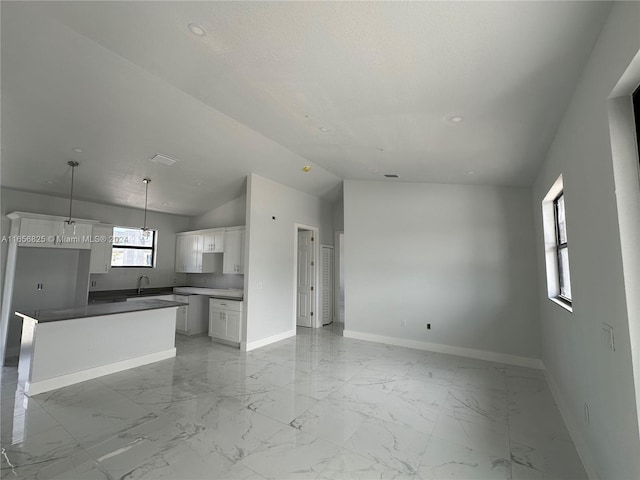 unfurnished living room featuring sink and vaulted ceiling