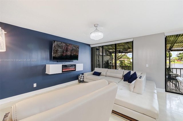 living room featuring a notable chandelier, a wall of windows, and plenty of natural light