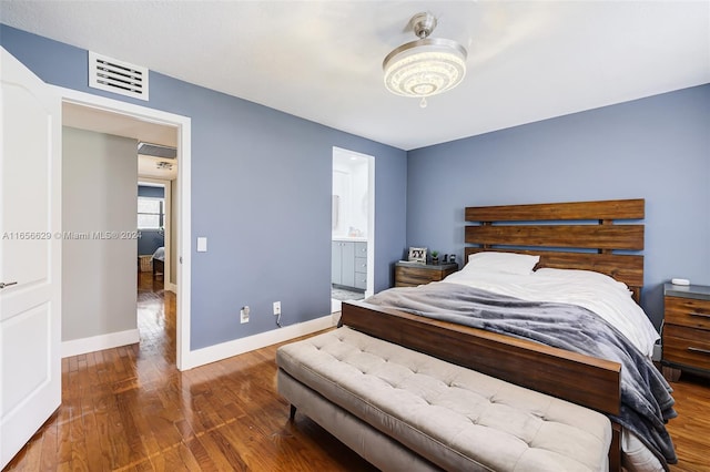 bedroom featuring connected bathroom and hardwood / wood-style flooring