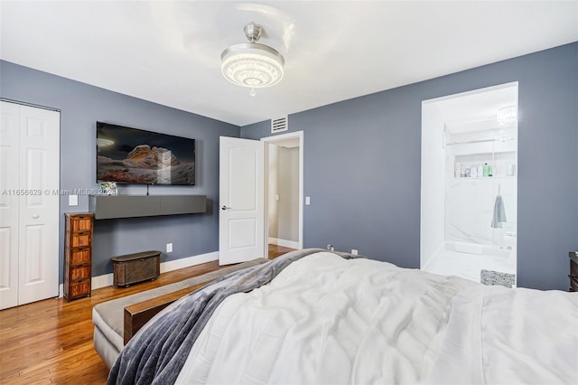 bedroom featuring hardwood / wood-style flooring and connected bathroom