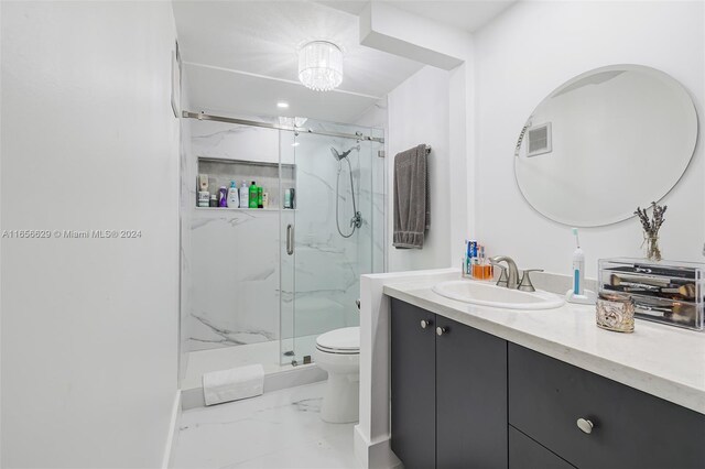 bathroom with a shower with shower door, vanity, and toilet