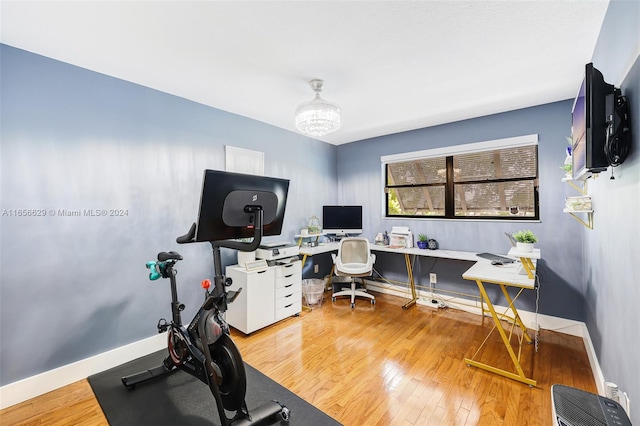 exercise room with a notable chandelier and hardwood / wood-style flooring