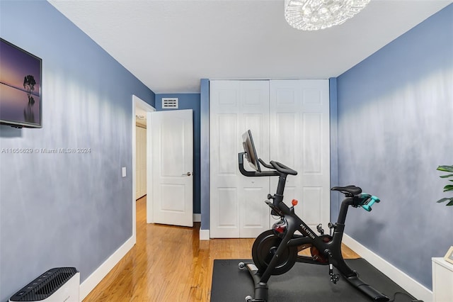 exercise room with light wood-type flooring