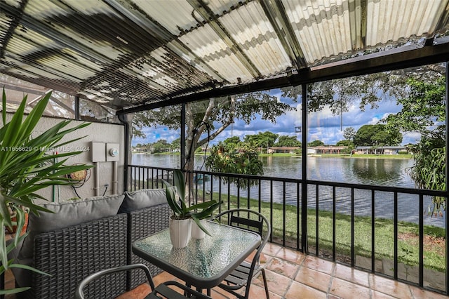 sunroom featuring a water view