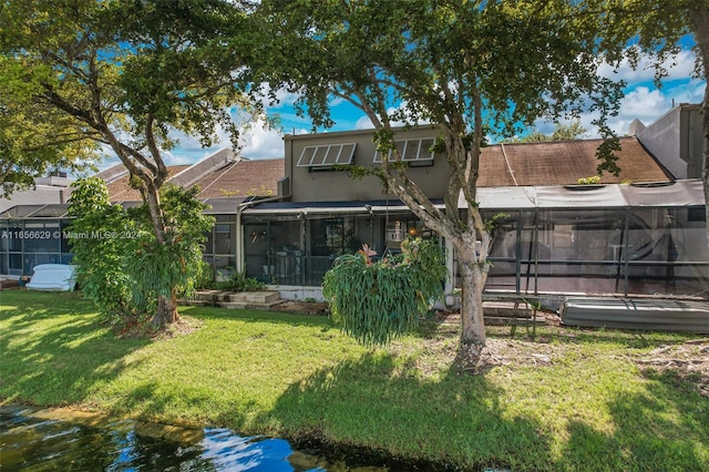 rear view of property featuring a lawn and a sunroom