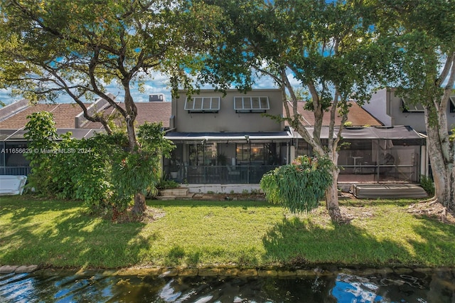 rear view of property featuring a sunroom and a lawn