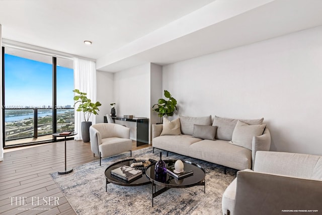 living room featuring hardwood / wood-style floors, expansive windows, and a water view