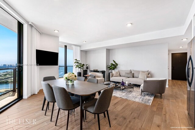 dining area featuring light hardwood / wood-style flooring and a water view