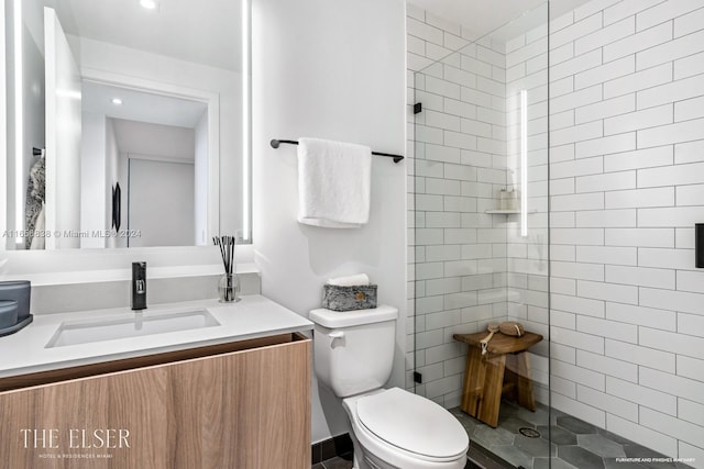 bathroom featuring tiled shower, vanity, and toilet