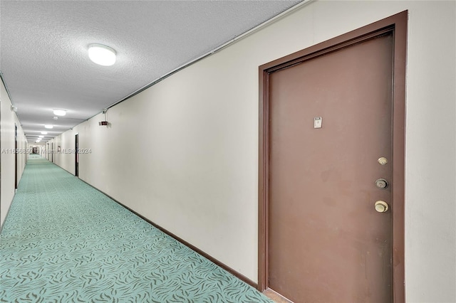 hallway featuring a textured ceiling and carpet floors