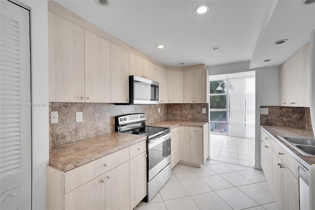 kitchen with stainless steel appliances, light tile patterned floors, and tasteful backsplash