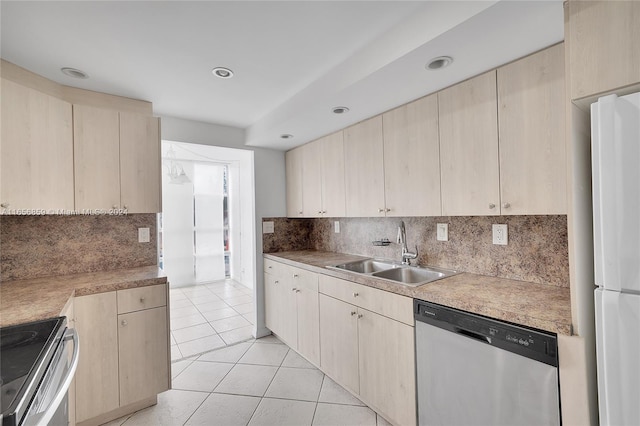 kitchen featuring light brown cabinetry, backsplash, stainless steel appliances, and sink