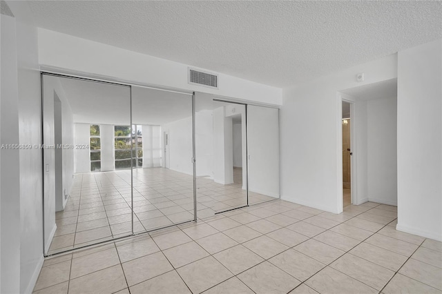 unfurnished bedroom featuring light tile patterned flooring and a textured ceiling