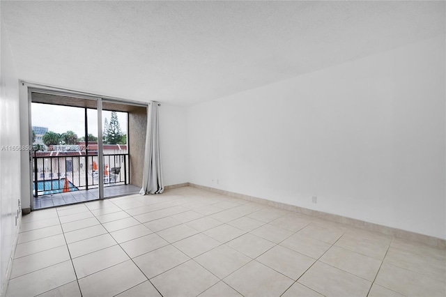 tiled empty room with a textured ceiling