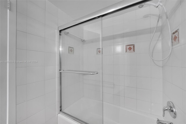 bathroom with bath / shower combo with glass door