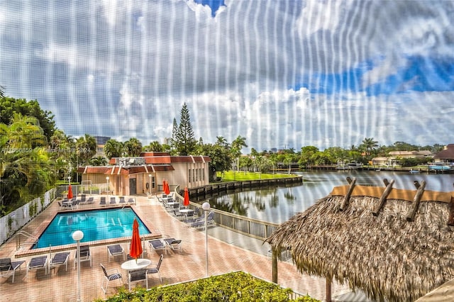 view of swimming pool with a patio and a water view