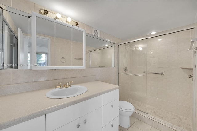 bathroom with vanity, an enclosed shower, backsplash, toilet, and tile patterned floors