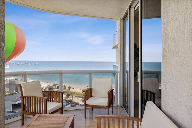 balcony featuring a beach view and a water view