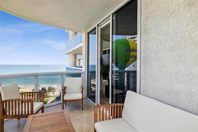 balcony featuring a beach view and a water view