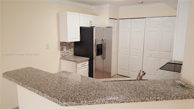 kitchen with kitchen peninsula, stainless steel fridge, white cabinets, and sink