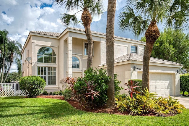 mediterranean / spanish-style house featuring a front yard and a garage