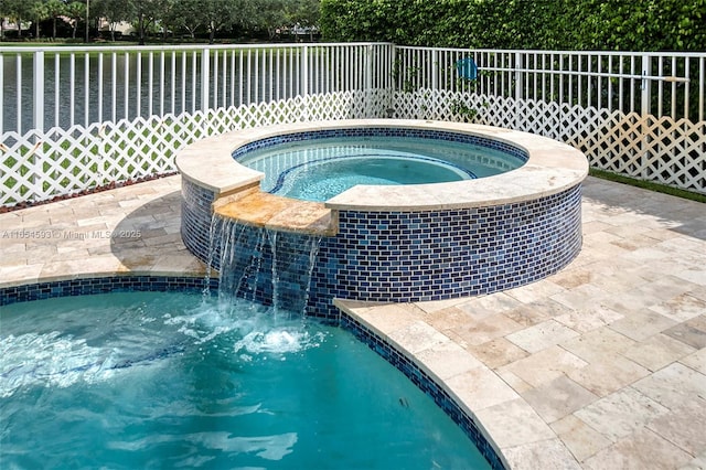 view of swimming pool with pool water feature and an in ground hot tub