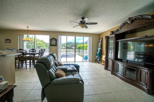 living room featuring ceiling fan, a textured ceiling, and light tile patterned flooring