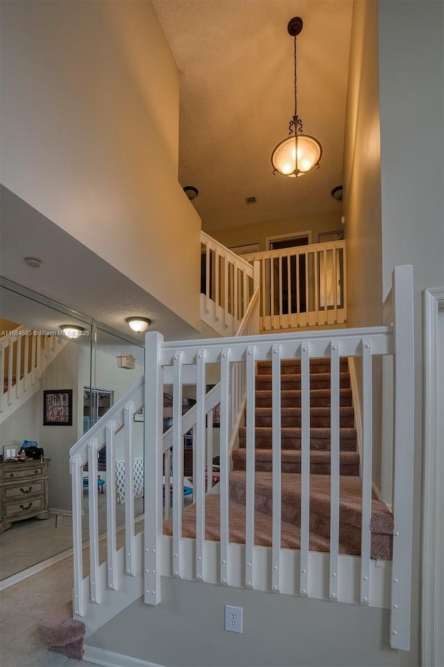 stairway featuring a high ceiling