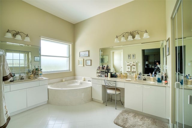 bathroom with vanity and tiled tub