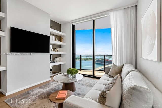 living room with a wall of windows and hardwood / wood-style flooring