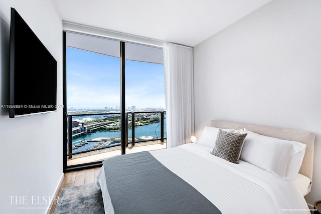 bedroom featuring expansive windows and light hardwood / wood-style floors