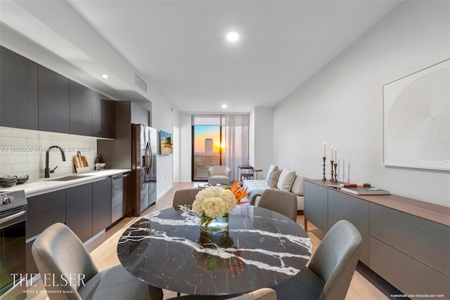 dining space featuring light hardwood / wood-style flooring and sink