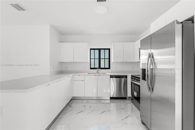 kitchen with kitchen peninsula, sink, white cabinets, and stainless steel appliances