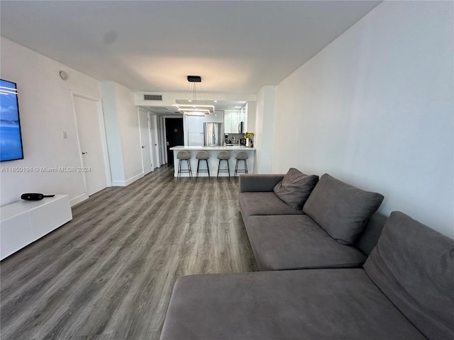 living room with wood-type flooring and a notable chandelier