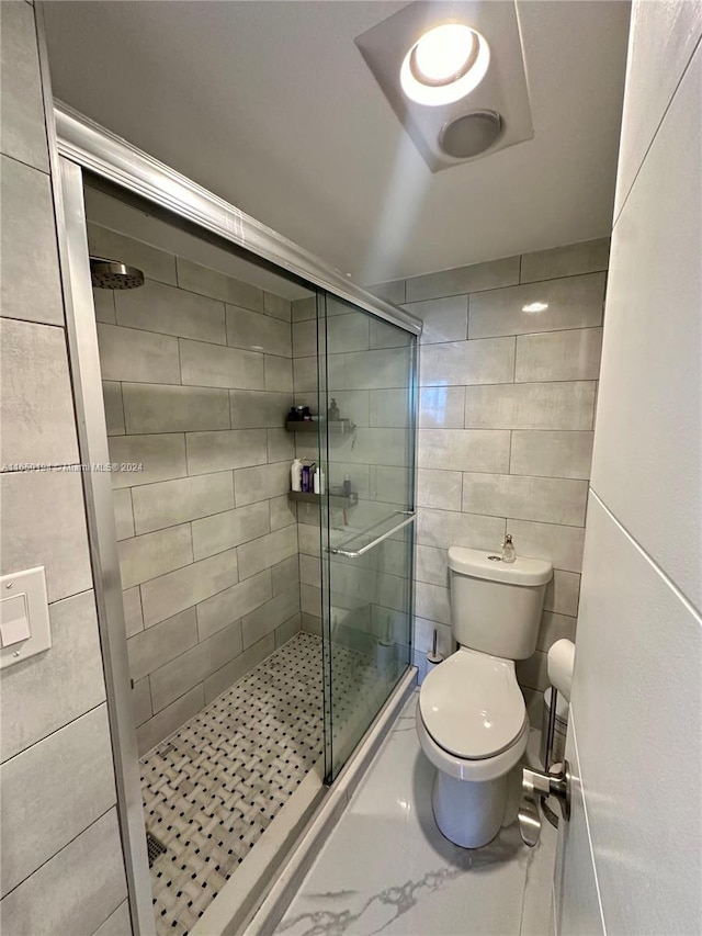 bathroom featuring tile walls, toilet, and walk in shower