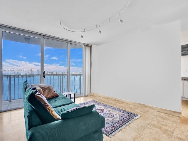 living room featuring expansive windows, a water view, and track lighting