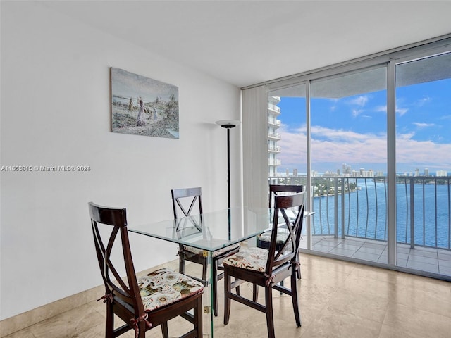 dining space featuring a water view and a wall of windows