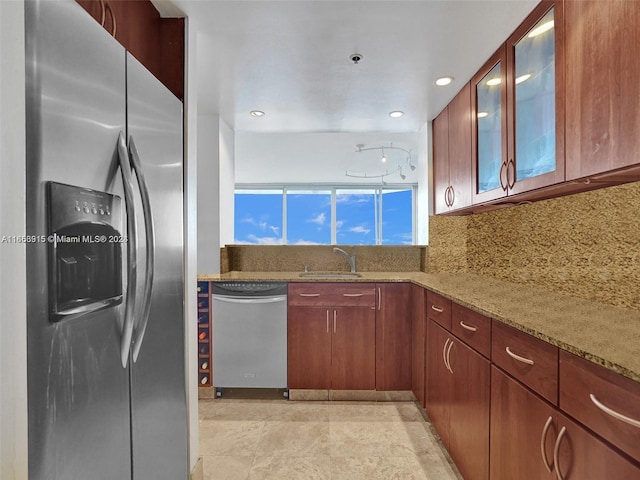 kitchen with tasteful backsplash, sink, stainless steel appliances, and light stone countertops