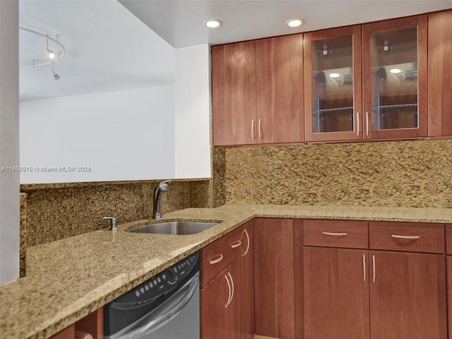 kitchen featuring dishwasher, sink, light stone countertops, and decorative backsplash