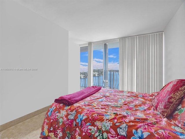 bedroom with a water view and access to outside