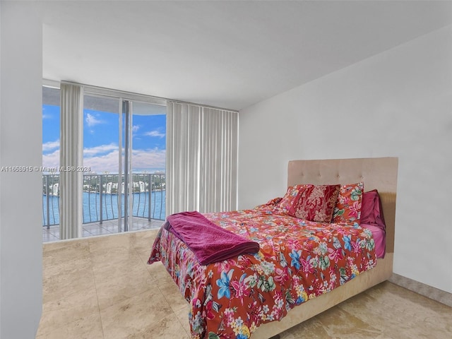 bedroom with access to outside, expansive windows, and a water view