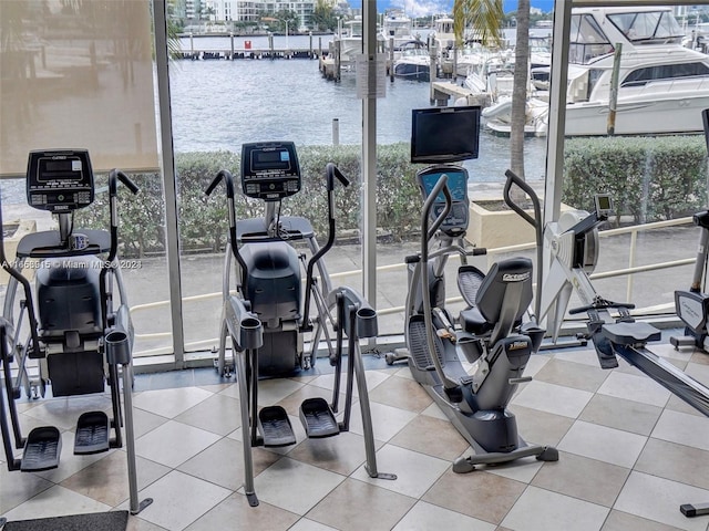 gym with plenty of natural light, floor to ceiling windows, and light tile patterned floors