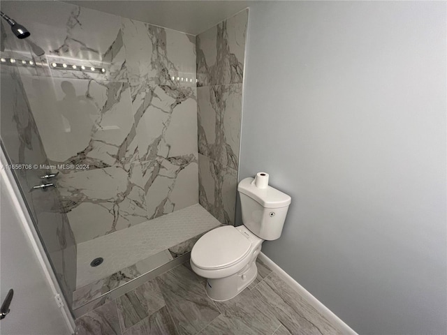 bathroom with toilet and a tile shower