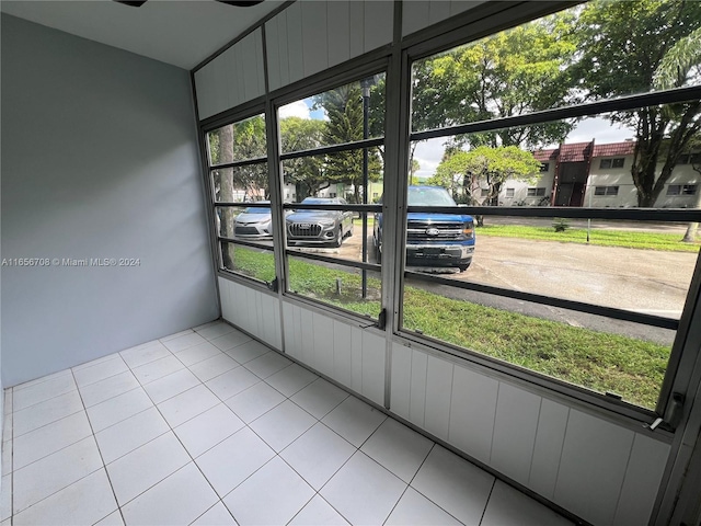 unfurnished sunroom featuring a healthy amount of sunlight and ceiling fan